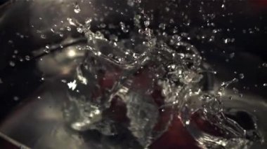 Soğan suyla birlikte tavaya düşer. Film, yavaş çekim 1000 fp. Yüksek kaliteli FullHD görüntüler