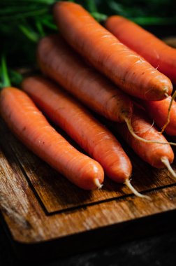 Kesme tahtasındaki havuçlar. Siyah bir masada..