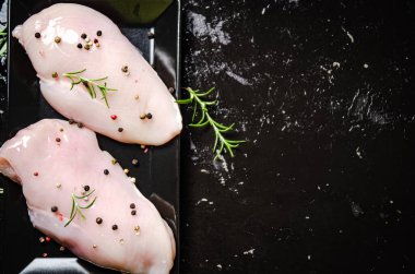Baharatlı taze tavuk filetosu. Siyah bir masada..