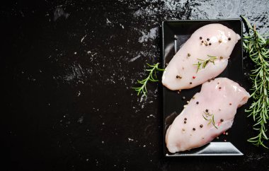 Baharatlı taze tavuk filetosu. Siyah bir masada..