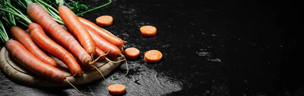 Carrots on a cutting board. On a black table.