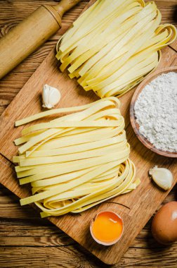 Ev yapımı makarna tagliatelle. Tahta bir masada..