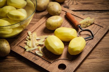 Taze soyulmuş patates. Tahta bir masada..