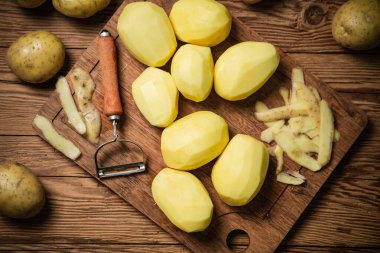 Taze soyulmuş patates. Tahta bir masada..