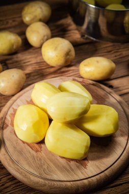 Taze soyulmuş patates. Tahta bir masada..