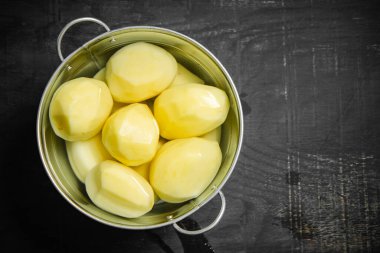 Taze soyulmuş patates. Siyah bir arkaplanda.