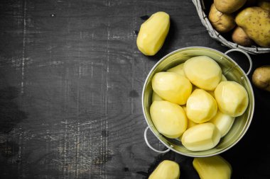 Taze soyulmuş patates. Siyah bir arkaplanda.