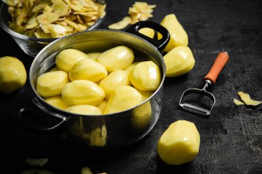 Taze soyulmuş patates. Siyah bir arkaplanda.