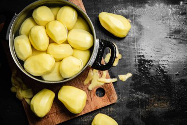 Taze soyulmuş patates. Siyah bir arkaplanda.
