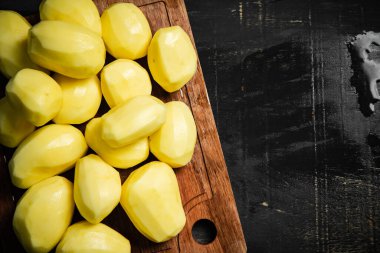 Taze soyulmuş patates. Siyah bir arkaplanda.