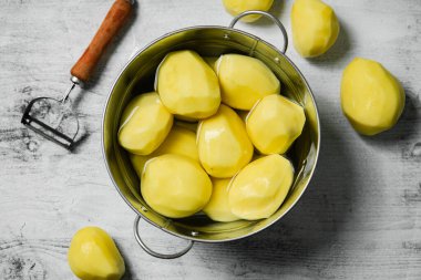 Taze soyulmuş patates. Beyaz bir masada..