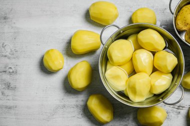 Taze soyulmuş patates. Beyaz bir masada..
