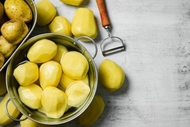 Taze soyulmuş patates. Beyaz bir masada..