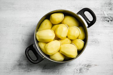 Taze soyulmuş patates. Beyaz bir masada..