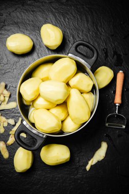 Taze soyulmuş patates. Siyah bir arkaplanda.