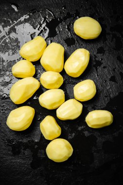 Taze soyulmuş patates. Siyah bir arkaplanda.