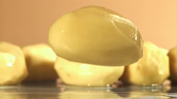 Geschilde Aardappelen Vallen Een Natte Tafel Gefilmd Een Hoge Snelheidscamera — Stockvideo