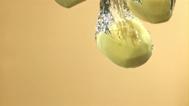 Soyulmuş patatesler suya düşer. 1000 fps 'de yüksek hızlı bir kamerayla çekildi. Yüksek kaliteli FullHD görüntüler