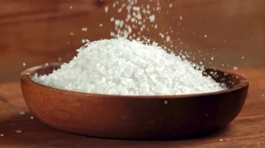Tuz ahşap bir tabağa düşer. 1000 fps 'de yüksek hızlı bir kamerayla çekildi. Yüksek kaliteli FullHD görüntüler