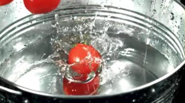 Domatesler bir kova suya düşer. 1000 fps 'de yüksek hızlı bir kamerayla çekildi. Yüksek kaliteli FullHD görüntüler