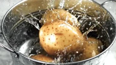 Patatesler bir kova suya düşer. 1000 fps 'de yüksek hızlı bir kamerayla çekildi. Yüksek kaliteli FullHD görüntüler