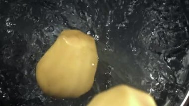 Soyulmuş patatesler kaynar suya düşer. 1000 fps 'de yüksek hızlı bir kamerayla çekildi. Yüksek kaliteli FullHD görüntüler