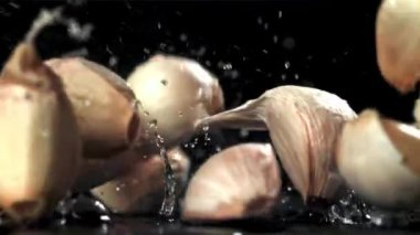 Taze sarımsak masaya düşer. Makro atış. 1000 fps 'de yüksek hızlı bir kamerayla çekildi. Yüksek kaliteli FullHD görüntüler