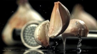 Sarımsak siyah bir masaya düşer. 1000 fps 'de yüksek hızlı bir kamerayla çekildi. Yüksek kaliteli FullHD görüntüler