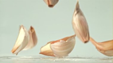Sarımsak su sıçramış bir şekilde ışık masasına düşer. 1000 fps 'de yüksek hızlı bir kamerayla çekildi. Yüksek kaliteli FullHD görüntüler
