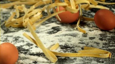 Makarna un ile tahtaya düşer. Yukarıdan bak. 1000 fps 'de yüksek hızlı bir kamerayla çekildi. Yüksek kaliteli FullHD görüntüler