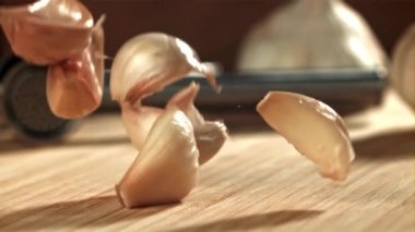Taze sarımsak kesme tahtasına düşer. 1000 fps 'de yüksek hızlı bir kamerayla çekildi. Yüksek kaliteli FullHD görüntüler