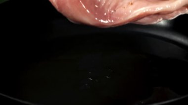 Tavuk filetosu tavaya düşer. 1000 fps 'de yüksek hızlı bir kamerayla çekildi. Yüksek kaliteli FullHD görüntüler