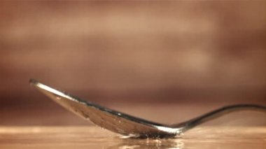 Tahta bir masaya bir kaşık düşer. 1000 fps 'de yüksek hızlı bir kamerayla çekildi. Yüksek kaliteli FullHD görüntüler