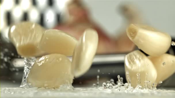 Knoblauch Fällt Auf Einen Hellen Tisch Mit Spritzern Gefilmt Mit — Stockvideo