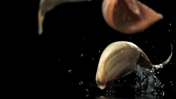 大蒜落在黑桌上 溅了些水花 在1000英尺每秒的高速相机上拍摄 优质Fullhd影片 — 图库视频影像