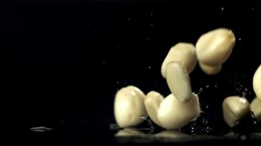 Taze sarımsak masaya düşer. Makro atış. 1000 fps 'de yüksek hızlı bir kamerayla çekildi. Yüksek kaliteli FullHD görüntüler