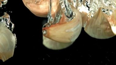 Taze sarımsak suyun altına düşer. 1000 fps 'de yüksek hızlı bir kamerayla çekildi. Yüksek kaliteli FullHD görüntüler