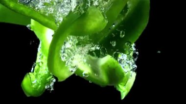 Dilimlenmiş dolmalık biber suyun altına düşer. 1000 fps 'de yüksek hızlı bir kamerayla çekildi. Yüksek kaliteli FullHD görüntüler