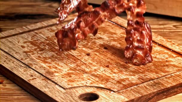 ベーコンのローストスライスは木製のテーブルに落ちます 1000Fpsで高速カメラで撮影しました 高品質のフルHd映像 — ストック動画