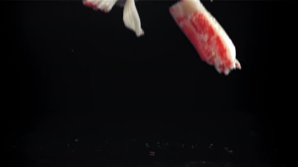 Frische Krabbenstäbchen Fallen Auf Schwarzem Hintergrund Gefilmt Mit Einer Hochgeschwindigkeitskamera — Stockvideo
