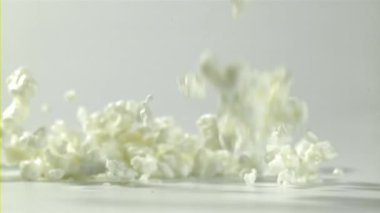 Beyaz arka plana dökülen taze süzme peynir. 1000 fps 'de yüksek hızlı bir kamerayla çekildi. Yüksek kaliteli FullHD görüntüler