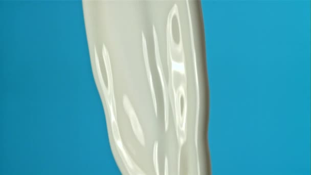 Melk Spat Een Blauwe Achtergrond Gefilmd Een Hoge Snelheidscamera Met — Stockvideo