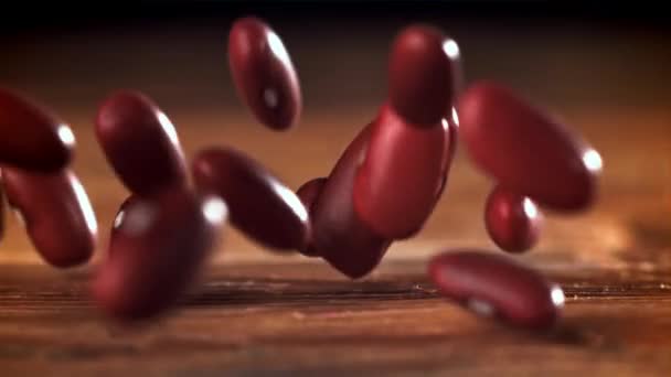 Frijoles Rojos Cayendo Sobre Una Mesa Madera Filmado Una Cámara — Vídeo de stock