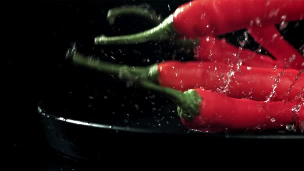 チリの唐辛子はプレートにスプラッシュで落ちる 黒い背景に 1000Fpsで高速カメラで撮影しました 高品質のフルHd映像 — ストック動画