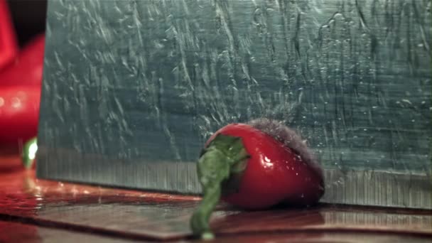 Het Mes Snijdt Chili Peper Met Een Scheutje Water Gefilmd — Stockvideo