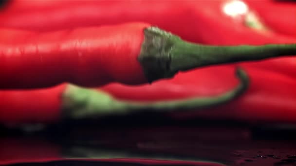 Chilli Papričky Padají Cákáním Talíře Černém Pozadí Natočeno Vysokorychlostní Kameře — Stock video
