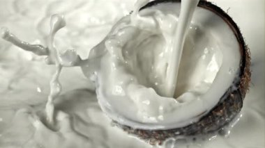 Süt yarım hindistan cevizinin üzerine dökülür. 1000 fps 'de yüksek hızlı bir kamerayla çekildi. Yüksek kaliteli FullHD görüntüler