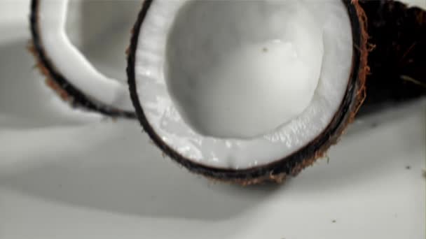 ココナッツの半分はスプラッシュでミルクに落ちる 1000Fpsで高速カメラで撮影しました 高品質のフルHd映像 — ストック動画