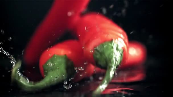 Chili Peppers Fall Wet Black Table Filmed High Speed Camera — Stock Video