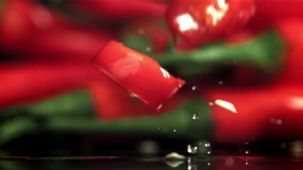 Kawałki Papryki Chili Spadające Czarne Tło Nagranie Szybkiej Kamerze Prędkością — Wideo stockowe